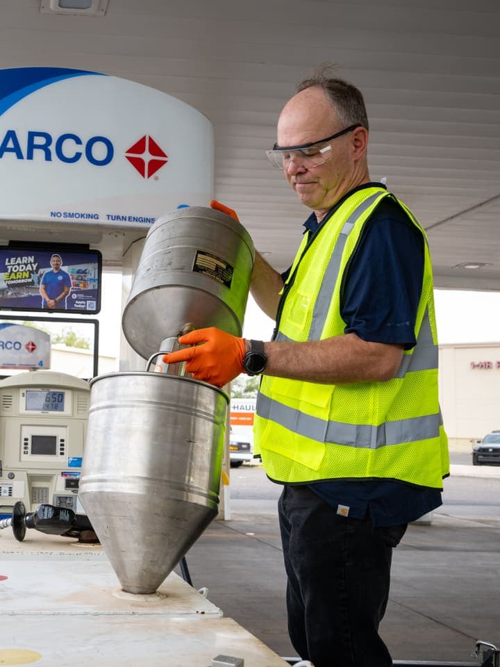 GTI tech carrying a tank filter at an ARCO site